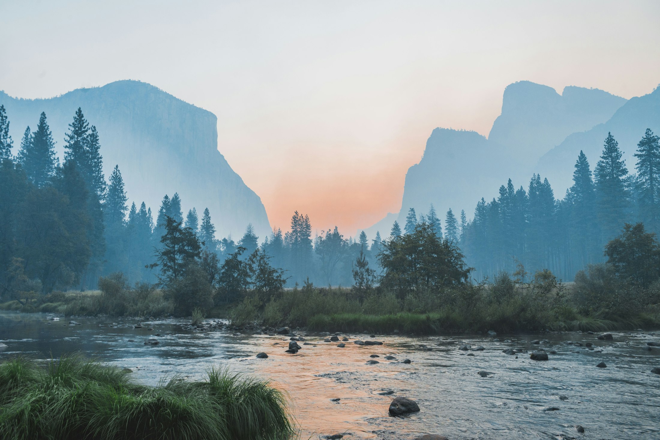 A river running through a misty valley at dawn